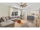 Spacious living area with hardwood floors, sectional couch, and adjacent kitchen featuring a large island at 14306 Paradise Tree Dr, Orlando, FL 32828