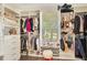 Spacious walk-in closet with ample storage and natural light from the window with custom shelving and clothing racks at 14306 Paradise Tree Dr, Orlando, FL 32828
