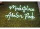 A neon sign displays 'Marketplace Avalon Park' against a background of lush green foliage, adding a modern touch at 14306 Paradise Tree Dr, Orlando, FL 32828