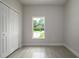 Empty bedroom with neutral walls, a large window, stylish flooring, and a closet creating a modern and inviting space at 144 Mandrake St, Orlando, FL 32811