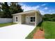 Single-story tan home featuring a modern design, well-kept landscaping, a concrete driveway, and a welcoming front entrance at 144 Mandrake St, Orlando, FL 32811