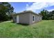 Exterior back view of home with grassy yard and surrounding trees in a serene setting at 144 Mandrake St, Orlando, FL 32811