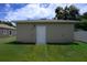 Side exterior of home with a white door surrounded by lush green lawn at 144 Mandrake St, Orlando, FL 32811