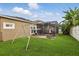 Spacious backyard features a lush lawn, swing set, and screened patio, perfect for outdoor entertaining at 15038 Masthead Landing Cir, Winter Garden, FL 34787
