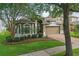 Charming two-story home with a manicured lawn, brick driveway, mature trees, and a two-car garage at 15038 Masthead Landing Cir, Winter Garden, FL 34787