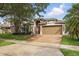 Beautiful two-story home with a manicured lawn, brick driveway, mature trees and a two-car garage at 15038 Masthead Landing Cir, Winter Garden, FL 34787