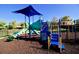 Community playground with a blue and green play structure with slides and climbing features on a mulch surface at 15038 Masthead Landing Cir, Winter Garden, FL 34787