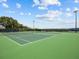 Well-maintained tennis courts featuring a green surface with a net and stadium lighting at 15038 Masthead Landing Cir, Winter Garden, FL 34787