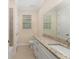 Bathroom with tile floors, long granite counters, single sink, and window at 16357 Se 88Th Ct, Summerfield, FL 34491