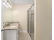 Bathroom featuring granite counters, double sink, and glass-enclosed shower at 16357 Se 88Th Ct, Summerfield, FL 34491