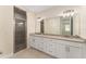 Spacious bathroom showcasing dual sinks, granite countertop, large mirror, and frameless glass shower at 16357 Se 88Th Ct, Summerfield, FL 34491