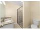 Bathroom featuring granite counters, single sink, glass-enclosed shower, and toilet at 16357 Se 88Th Ct, Summerfield, FL 34491