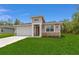 Inviting one-story home featuring a two-car garage, manicured lawn, and decorative stone accents at 16357 Se 88Th Ct, Summerfield, FL 34491