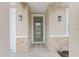 Close-up of the home's front door showcasing decorative glass and stylish exterior lighting fixtures at 16357 Se 88Th Ct, Summerfield, FL 34491