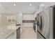 Bright kitchen with stainless steel appliances, granite countertops, and ample cabinet space at 16357 Se 88Th Ct, Summerfield, FL 34491