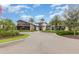 Community clubhouse with palm trees, landscaping, and a circular driveway at 17044 Goldcrest Loop, Clermont, FL 34714