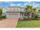 Charming two-story home featuring a brick driveway, two car garage, and manicured landscaping at 17044 Goldcrest Loop, Clermont, FL 34714