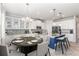 Open-concept kitchen featuring white cabinets, stainless steel appliances, and a dining table at 17044 Goldcrest Loop, Clermont, FL 34714