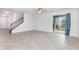 Large living room with tile floors, stairs, and a sliding door to a patio at 17044 Goldcrest Loop, Clermont, FL 34714