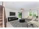 Cozy living room with ceiling fan, stairs, and sliding door to outdoor space at 17044 Goldcrest Loop, Clermont, FL 34714