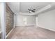 Spacious main bedroom with a trey ceiling, ceiling fan, and a decorative wood accent wall at 17044 Goldcrest Loop, Clermont, FL 34714