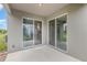Outdoor patio featuring a concrete slab and a wall with sliding glass doors at 17044 Goldcrest Loop, Clermont, FL 34714