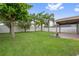 Large, grassy backyard with a white fence and covered patio area at 1961 Continental St, St Cloud, FL 34769