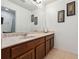 Bathroom with a wooden vanity, a large mirror, and framed wall decor at 1961 Continental St, St Cloud, FL 34769
