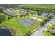 An aerial view showcasing community amenities featuring a basketball and tennis court near a pond at 1961 Continental St, St Cloud, FL 34769
