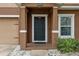 Close up of front porch showing covered area, dark front door, and trimmed landscaping at 1961 Continental St, St Cloud, FL 34769