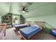 Shared bedroom with a fan, mint-green walls, built-in shelving, and two twin beds with blue quilts at 2050 Jan Lan Blvd, St Cloud, FL 34772