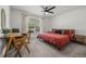 Relaxing bedroom with a ceiling fan, a window view to the backyard, a desk and chair, plus a comfy bed at 2050 Jan Lan Blvd, St Cloud, FL 34772
