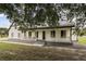 Beautiful white home featuring a cozy porch and meticulously maintained landscaping at 2050 Jan Lan Blvd, St Cloud, FL 34772