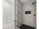 Modern walk-in shower featuring marble tiling, black hardware, and a unique hexagonal tile floor at 2050 Jan Lan Blvd, St Cloud, FL 34772