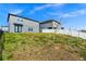 View of the backyard, showcasing the grassy area with a white fence and a partial view of the home's exterior at 2222 Derwent Dr, Davenport, FL 33896