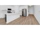 Bright kitchen boasts a stainless refrigerator, white cabinetry, gold accents, and wood-look tile flooring at 2222 Derwent Dr, Davenport, FL 33896