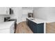 Stylish kitchen offers stainless appliances, white cabinets and a bold blue island with a breakfast bar at 2222 Derwent Dr, Davenport, FL 33896