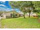 Spacious backyard with lush green lawn, mature trees, and a screened in back porch at 2342 Audley St, Oviedo, FL 32765