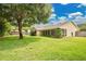 Spacious backyard with lush green lawn, mature trees, and a screened in back porch at 2342 Audley St, Oviedo, FL 32765