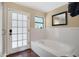 Bright bathroom features a soaking tub and a glass-enclosed shower, and a door to the exterior at 2342 Audley St, Oviedo, FL 32765
