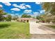 Charming single-story home featuring a two-car garage, well-maintained lawn, and mature trees under a beautiful sky at 2342 Audley St, Oviedo, FL 32765
