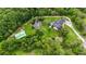 Aerial view of estate featuring the home, pond and outbuilding among lush trees at 23647 Seneca Ridge Ct, Christmas, FL 32709