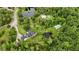 An aerial view shows the home, pool, pond and outbuilding set on acreage amidst lush trees at 23647 Seneca Ridge Ct, Christmas, FL 32709