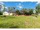 Large grassy backyard showcasing a screened-in pool area and mature landscaping for privacy at 23647 Seneca Ridge Ct, Christmas, FL 32709