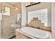 Modern bathroom with a glass-enclosed shower and a separate soaking tub with stylish tile surround at 23647 Seneca Ridge Ct, Christmas, FL 32709