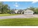 Charming exterior view of home with a three car garage and long driveway at 23647 Seneca Ridge Ct, Christmas, FL 32709