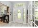 Bright and inviting foyer with light wood floors and a transom window above the front door at 23647 Seneca Ridge Ct, Christmas, FL 32709