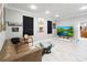 Bright living room with leather sofa, light floors, and a large-screen television display at 23647 Seneca Ridge Ct, Christmas, FL 32709