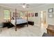 Spacious main bedroom with four poster bed, decorative artwork, and ensuite bathroom at 23647 Seneca Ridge Ct, Christmas, FL 32709