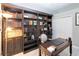 Office with built-in bookcases, a wooden desk, and light wood flooring at 23647 Seneca Ridge Ct, Christmas, FL 32709